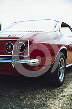 Vertical selective closeup shot of the taillight of a red coupe car