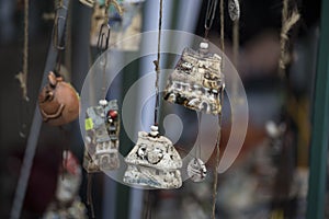 Vertical selective focus closeup of hanging ceramic figures