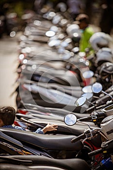 Vertical selective focus shot of a kid sitting in a motorcycle