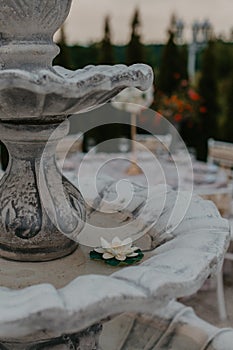 Vertical shallow focus shot of a fountain in an outdoor wedding ceremony reception decorations