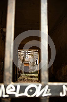 Vertical shot of an abandoned yard through the railings