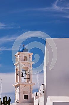 Vertical shot of the Anastasis Church with its Blue Dome and Tower in Santorini, Greece photo