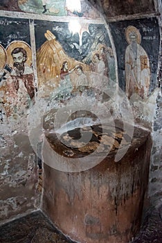 Vertical shot of an ancient tank on old Peeled wall with religious painting of Christianity