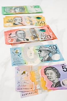 Vertical shot of Australian dollar banknotes on the white background