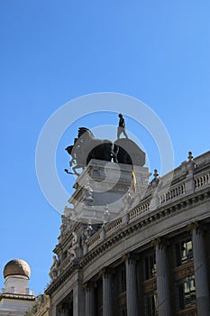 Vertical shot of The Banco Bilbao Vizcaya under a blue sky and sunlight in Madrid, Spain