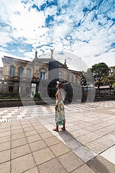 Vertical shot of beautiful Afro-descendant woman looking around on a sunny day in the city of San Jose in Costa Rica with the