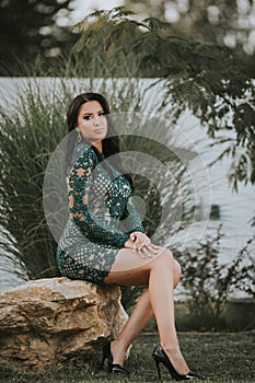 Vertical shot of a beautiful Bosnian Caucasian woman wearing a formal dress, posing outdoors