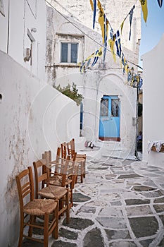 Vertical shot of a beautiful bystreet with flags hanged in the air in Paros, Greece