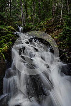 Vertical shot of a beautiful cascading waterfall in the middle of a forest