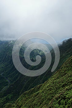 Vertical shot of beautiful forested mountains from the Stairway to Heaven in Ohau, Hawaii