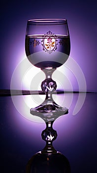 Vertical shot of a beautiful glass with a pattern and a reflection on the table