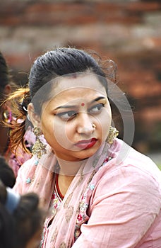 Vertical shot of a beautiful Indian woman with a red bindi and traditional jewelry looking aside