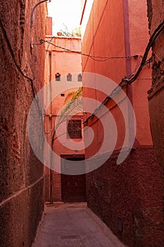 Vertical shot of a beautiful and narrow passageway in Marocco surrounded by orange buildings