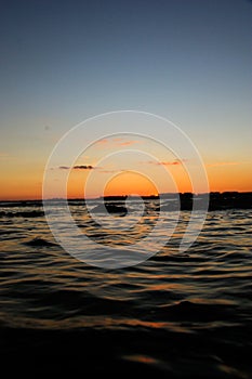 Vertical shot of the beautiful sea under the sunset sky at La Perouse