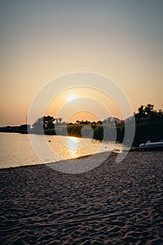 Vertical shot of a beautiful shoreline of a beach with a sunset in the background