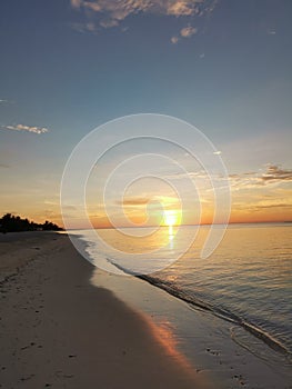 Vertical shot of a beautiful sunset over a calm sea shore