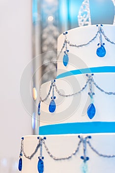 Vertical shot of a beautiful wedding cake with blue diamond decorations