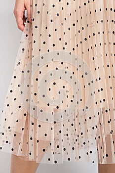 Vertical shot of a beige skirt with black dots in a female model photo