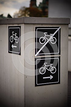 Vertical shot of bicycle direction signs on a metal surface