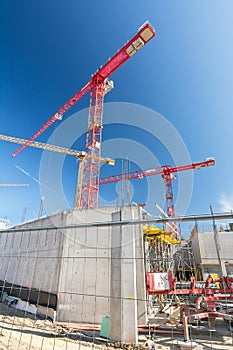 Vertical shot of big construction site with construction fence and cranes