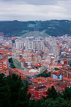 Vertical shot of Bilbao, with the curvy  titanium-clad Guggenheim  museum and hill forests photo