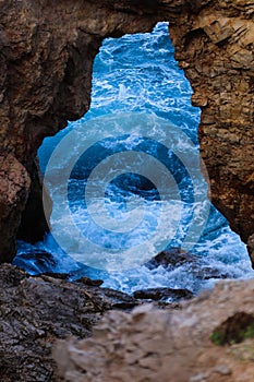 Vertical shot of the blue ocean opening from a rock view in Menorca. Islas Baleares. Spain.