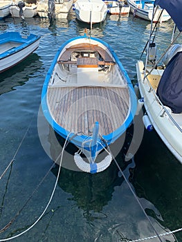 Vertical shot of a boat with a blue border docked in a harbor