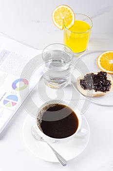 Vertical shot.Break at work, quick snack with coffee, orange juice, bun with jam. Morning traditional breakfast.Businessman`s life