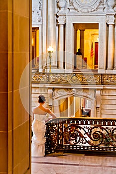 Vertical shot of a bride leaned on a railing in the San Francisco City Hall