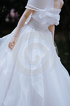 Vertical shot of the bride leaning right in a beautiful white wedding dress