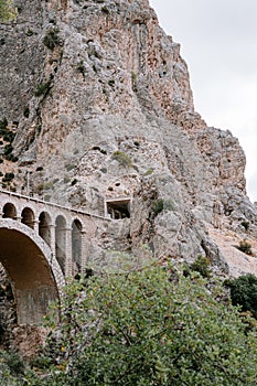 Vertical shot of a bridge leading to a tunnel in a rockface in Caminito del Ray, Spain.