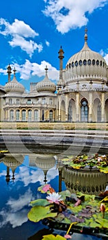 a vertical shot of Brighton's Royal Pavilion reflected in the pond ahead on a sunny day