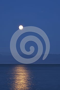 Vertical shot of a brilliant moon over the Jordan River