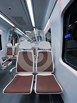 Vertical shot of the brown white seats in the interior of a train wagon