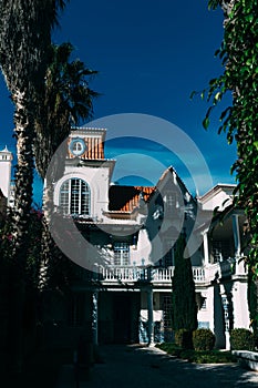 Vertical shot of a building in Estoril, Portugal with a yard with different plants