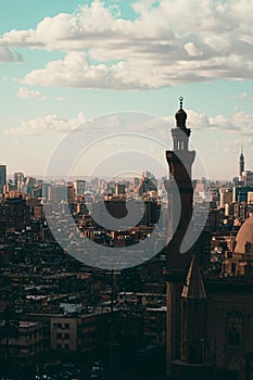 Vertical shot of Cairo rooftops, view from the Salah Al Din castle area. Mosqsue minaret in front, huge city and buildings going