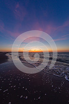 Vertical shot of the calm ocean during the sunset in Vrouwenpolder, Zeeland, Netherlands