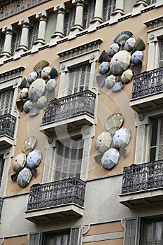 Vertical shot of the Casa Bruno Cuadros building decorated with umbrellas and hand fans in Spain photo