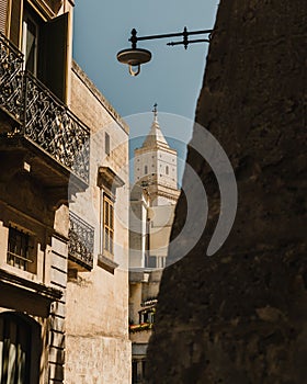 Vertical shot of the Cathedral of San Sabino seen between buildings in Bari, Italy