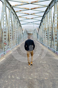 Vertical shot of a of a Caucasian white man on the bridge