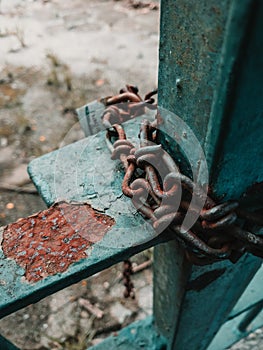 Vertical shot of chains on an old rusty railing