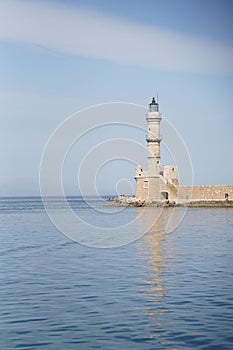 Vertical shot of Chania Lighthouse reflecting on the surface of the water, Crete, Greece