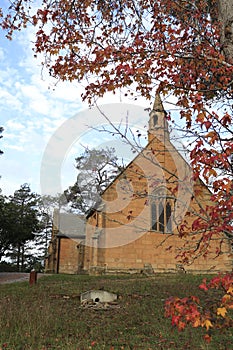 Vertical shot of a chapel surrounded by autumn trees