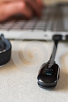 Vertical shot of charging smart band on laptop