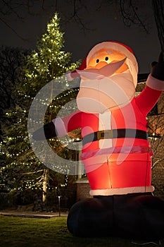 Vertical shot of Christmas lighting and Christmas decoration with a funny dancing Santa