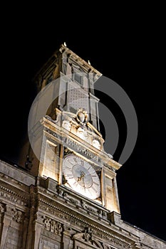 Vertical shot of the clock tower of the Giureconsulti Palace at night in Milan, Italy photo