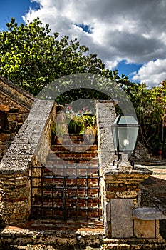 Vertical shot of closed metal bars in front of small stairs in Altos de Chavon, Dominican republic