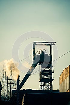 Vertical shot of coal mining equipment near the smoke outdoors