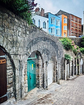 Vertical shot of cobblestone alley colorful buildings in background Penniless Cove hill Tenby Wales