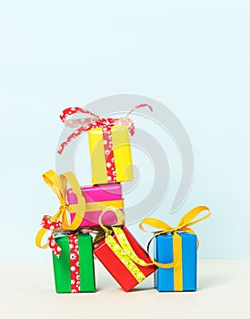 Vertical shot of colorful gift boxes stacked on a pastel background